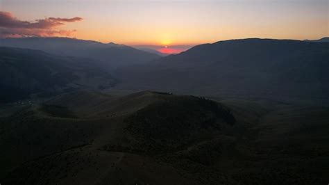 Premium Photo | Red rays of the sun at sunset among the mountains