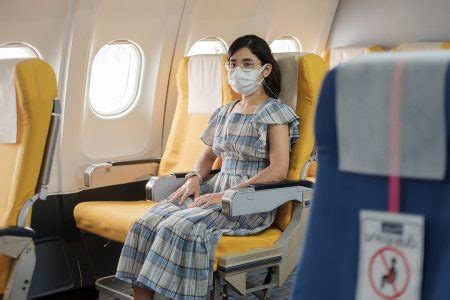 Mulher usando máscara facial protetora sentada em avião ou público