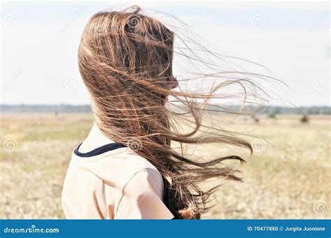 La Jeune Fille Se Tient Dans Le Domaine Et Le Vent Flotte Ses Cheveux