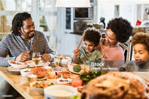 Happy Black Family Enjoying During Thanksgiving Dinner At Dining Table ...