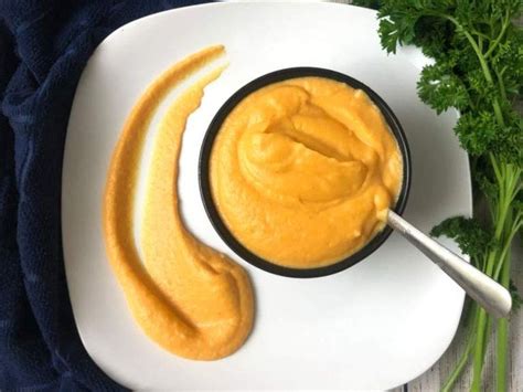 A White Plate Topped With An Orange Dip