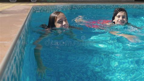 Two Happy Teenagers A Brother And Sister Are Swimming In A Race In The Pool Slow Motion