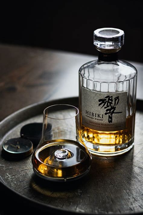 A Bottle Of Whisky Sitting On Top Of A Wooden Table Next To A Glass Cup