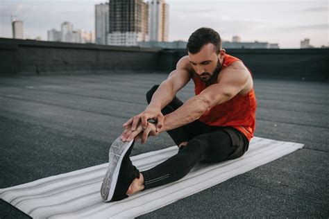 Premium Photo Handsome Sportsman Stretching On Yoga Mat On Roof