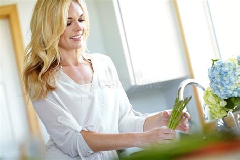 Always Wash Your Vegetables Attractive Blonde Woman Washing Vegetables In Her Kitchen At Home