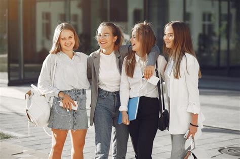 Les étudiants sur le campus avec des livres et des sacs Photo Gratuite