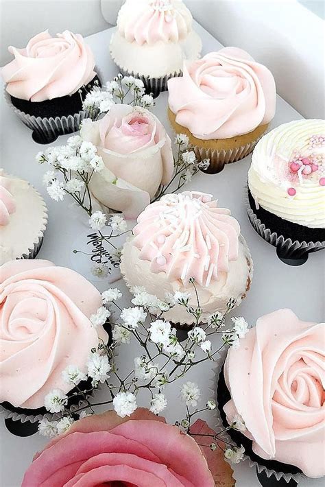 There Are Many Cupcakes With Pink Frosting And Flowers On The Top One