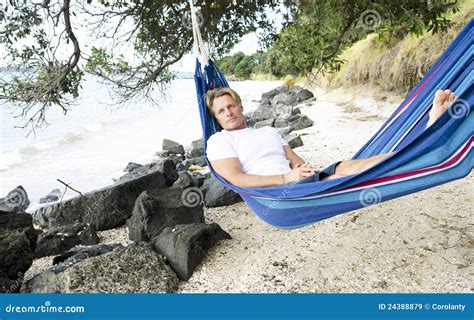 A Man Happily Relaxing In A Hammock On The Beach Stock Image Image