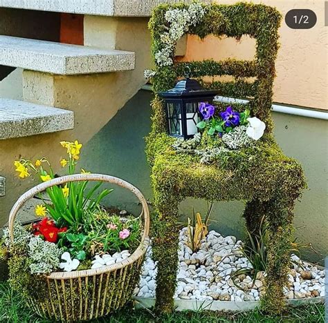 A Chair Made Out Of Moss Sitting Next To A Basket Filled With Flowers