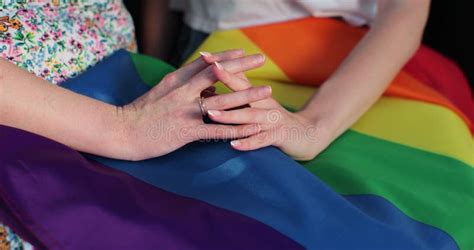 Close Up Lesbian Couple In Love Holding Hands On Rainbow Flag Lgbt