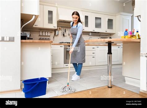 Young Woman Using Mop To Clean Floor Stock Photo Alamy