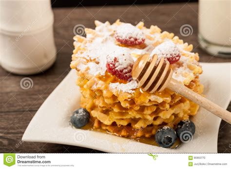 Belgian Waffles With Raspberries And Sieving Sugar Powder And Honey