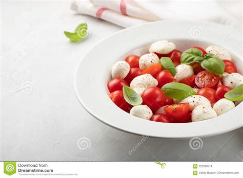 White Plate Of Classic Delicious Caprese Salad With Ripe Tomatoes