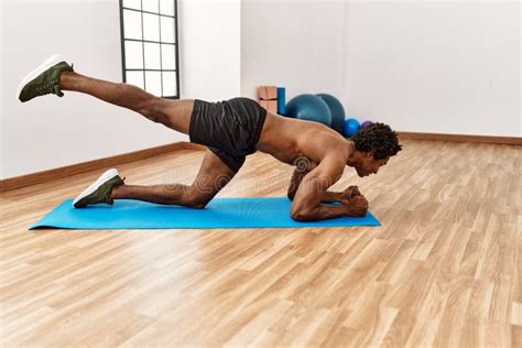 Young African American Man Training Abs Exercise At Gym Stock Image