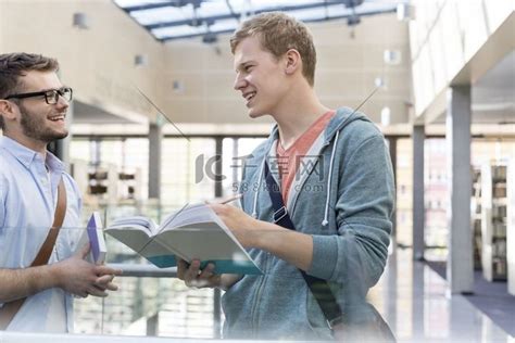 快乐的朋友在大学走廊看书时聊天高清摄影大图 千库网