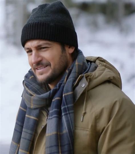 a man wearing a hat and scarf in the snow