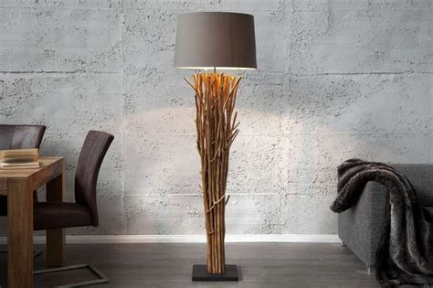 A Lamp That Is Next To A Couch And Chair In A Room With Concrete Walls