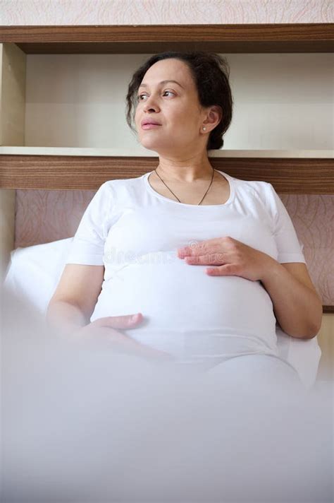 Close Up Pregnant Woman Sitting On Bed Stroking Her Big Belly