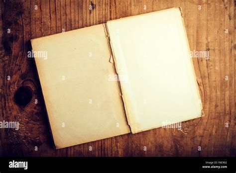 Top View Of Old Open Book With Blank Pages On Wooden Desk As Copy Space