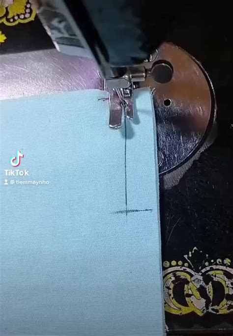 The Sewing Machine Is Working On The Blue Material That Has Been