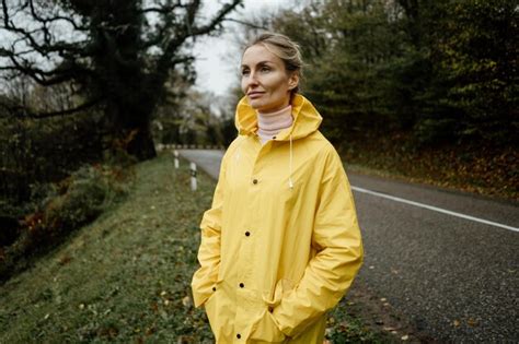 Premium Photo Middle Aged Woman In Yellow Raincoat Walking In Rainy