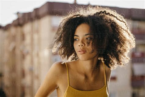 Beautiful Woman With Black Frizzy Hair Looking Away During Sunny Day