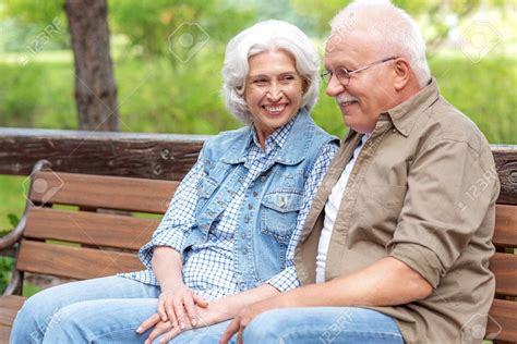 Happy Old Married Couple Is Sitting On Bench In Park Together They Are