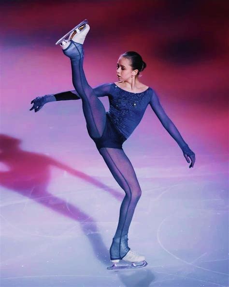 A Female Figure Skating On The Ice In A Blue Dress And Black Tights