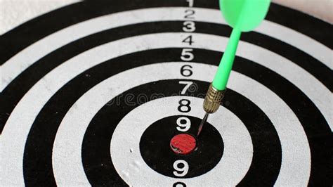 Green Dart Arrow Hitting In The Target Center Of Dartboard With Post