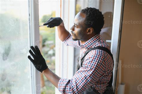 handsome young african american man installing bay window in new house
