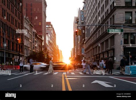 Diverse Crowd Of Women And Men Walking Across A Busy Intersection On