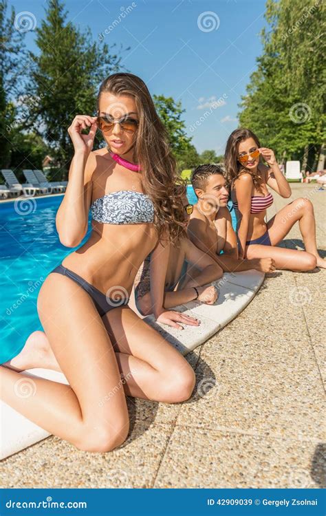 Beautiful Woman In Bikini Posing On The Edge Of The Swimming Pool