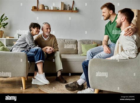 A Gay Couple Sits On A Couch With Parents Sharing A Moment Of Togetherness Stock Photo Alamy