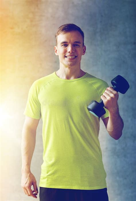 Hombre Sonriente Con Pesa De Gimnasia En Gimnasio Foto De Archivo