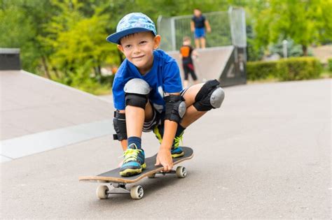 Hermoso Ni O Feliz En Su Patineta En Cuclillas Y Balance Ndose En La