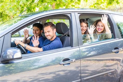 Grupo De Personas En El Coche Agitando Las Manos Foto Premium