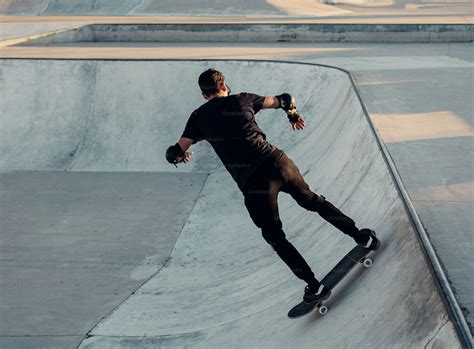 A Man Riding A Skateboard Up The Side Of A Ramp Photo Trying Image On