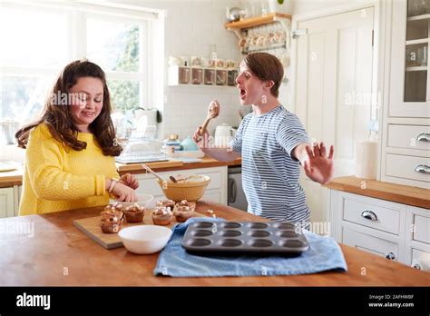 Young Downs Syndrome Couple Decorating Homemade Cupcakes With