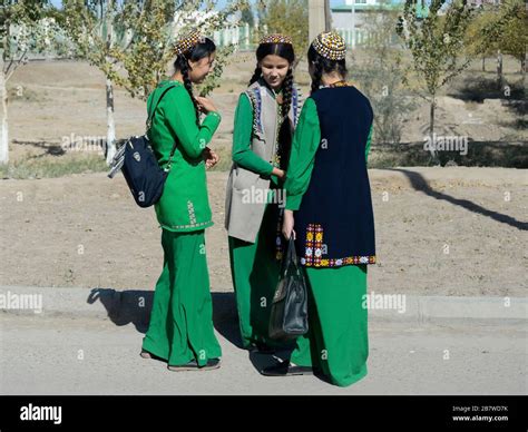 Three student young girls with braids wearing Turkmenistan national dress used as school uniform ...