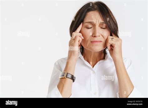 Mature Woman With Headache Frowning While Rubbing Her Temples Isolated Over White Background