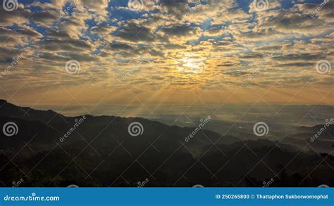 Bright Sunlight Shining Through Hole Of Blue And Clouds Sky To Dark