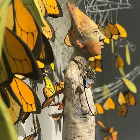 A Statue Is Standing In Front Of Many Butterflies