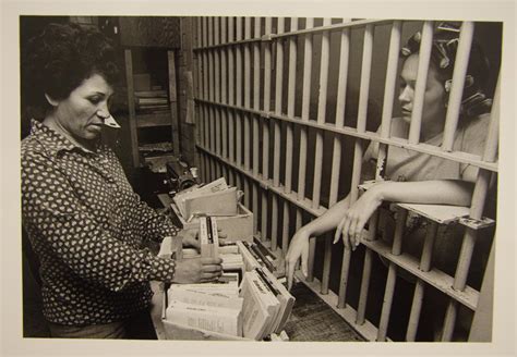 [Female Travis County Jail worker offering books to a female inmate ...