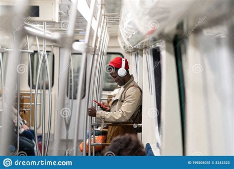 Afro American Passenger Man In Red Hat Stand In Subway Train Using