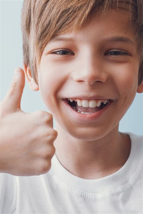 Menino De Sorriso Que Mostra Os Polegares Acima Imagem De Stock