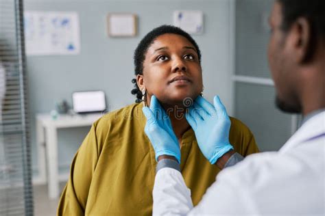 Black Woman at Health Checkup with Doctor Palpating Neck Stock Photo ...