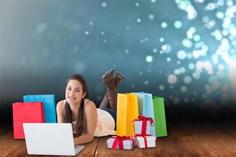 Premium Photo Brunette Lying And Using Her Laptop Against Shimmering Light Design Over Boards