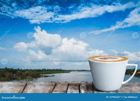 A White Cup Of Coffee On The Wooden Table By The River Stock Image