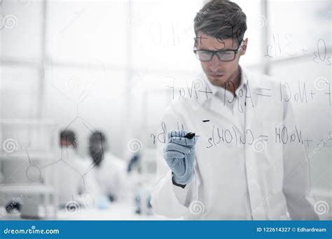 Serious Scientist Writes A Chemical Formula On A Glass Board Stock