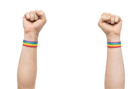 Premium Photo Hands With Gay Pride Rainbow Wristbands Shows Fist